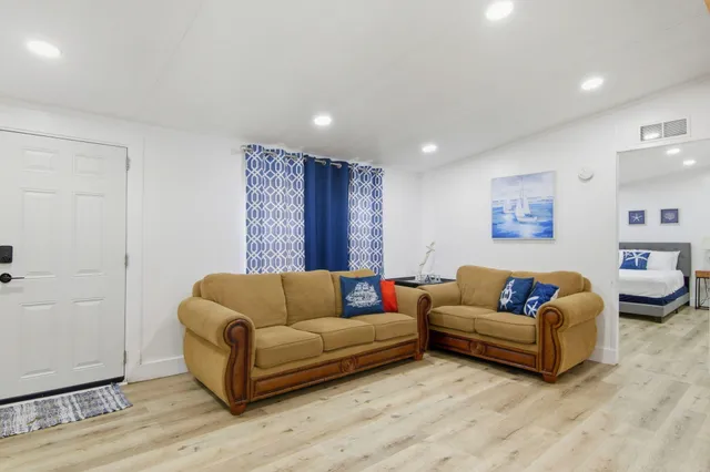 a living room with furniture and a wooden floor