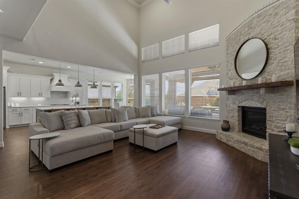 2801 Seabiscuit Road Celina, TX 75009 - Photo 6 of 39 Living room featuring a fireplace, dark wood-style floors, and a high ceiling