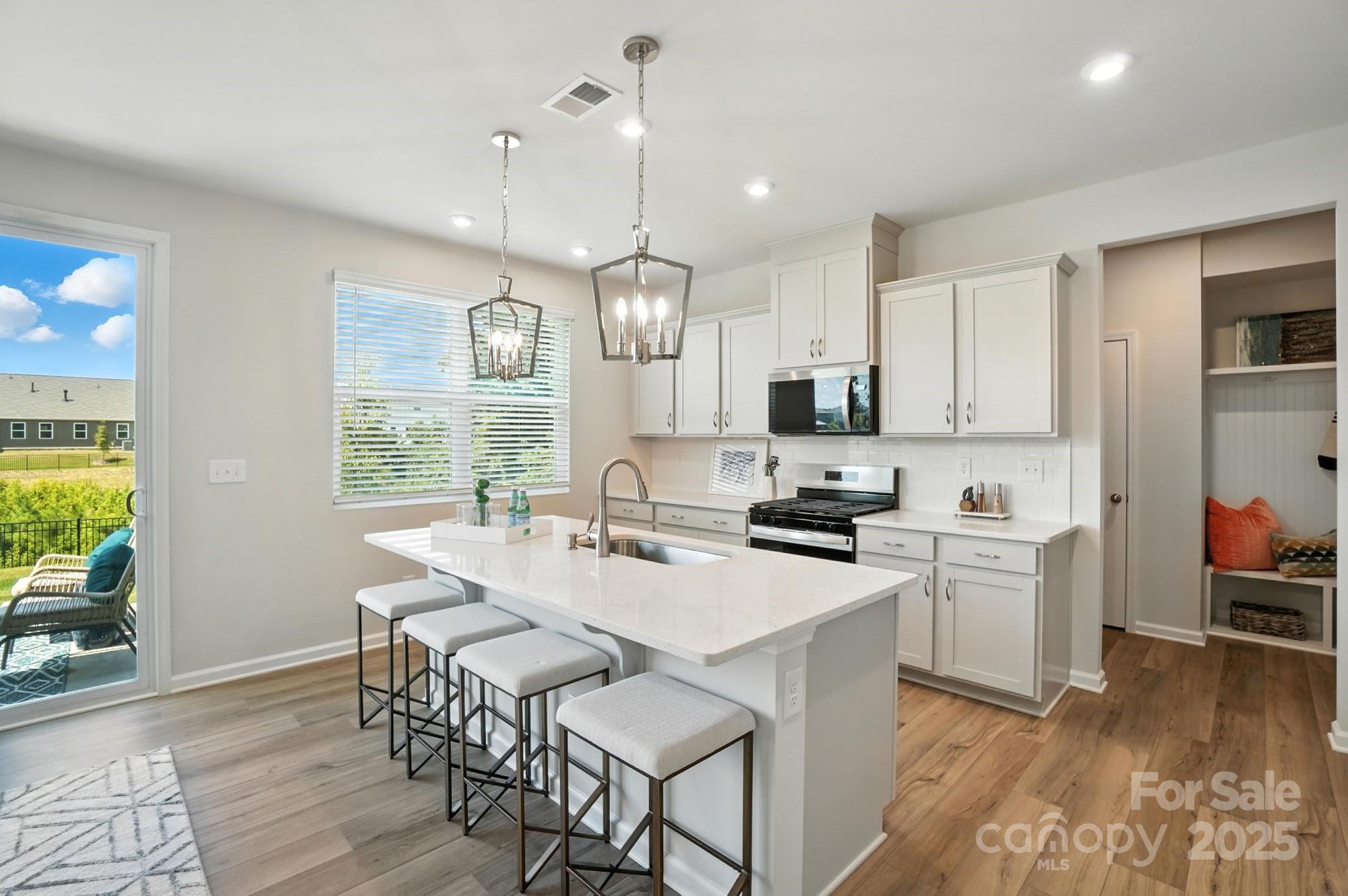 1217 Roscoe Court Monroe, NC 28112 - Photo 11 of 46 a kitchen with a stove a sink a dining table and chairs