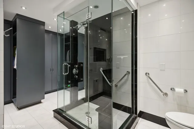 a bathroom with a glass shower door a sink and a mirror