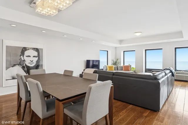 a living room with furniture a chandelier and a dining table