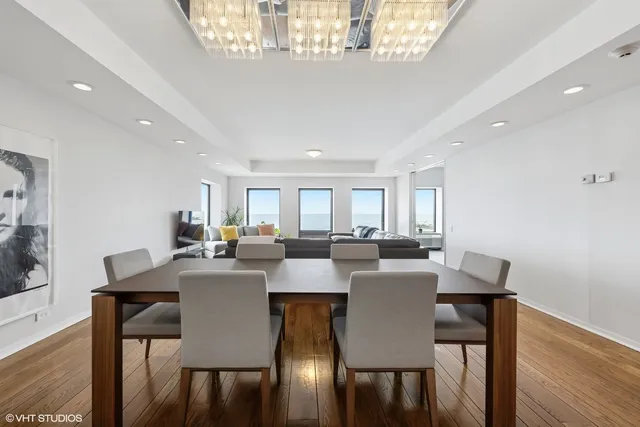 a view of a dining room with furniture a chandelier and wooden floor
