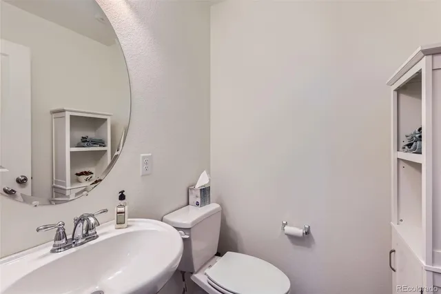 a bathroom with a toilet sink and mirror