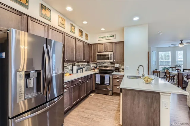 a kitchen with stainless steel appliances granite countertop a refrigerator stove top oven and sink