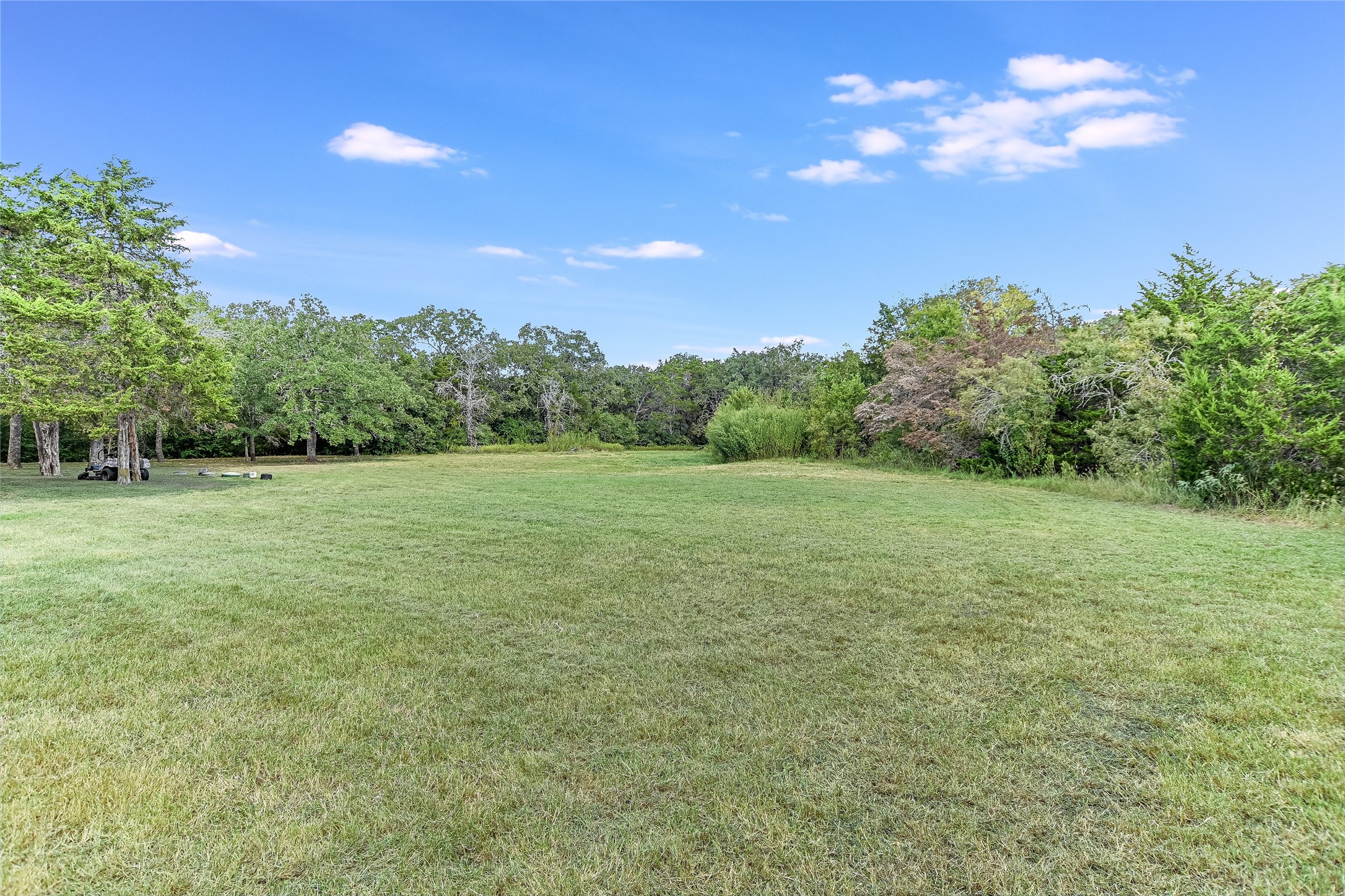 741 Knobbs Road McDade, TX 78650 - Photo 25 of 37 a view of a green field with trees in the background
