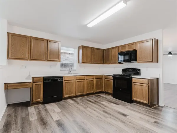 a kitchen with granite countertop a stove top oven sink and cabinets