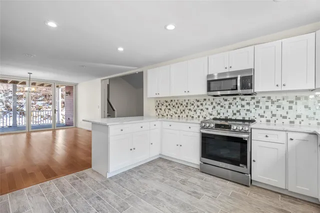 a kitchen with stainless steel appliances granite countertop a stove a sink and a microwave