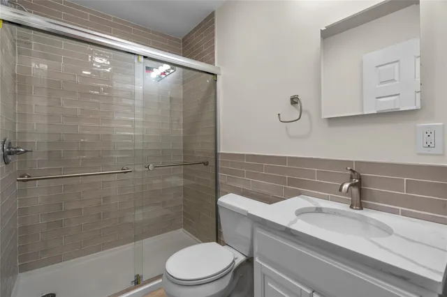 a bathroom with a sink a toilet and shower