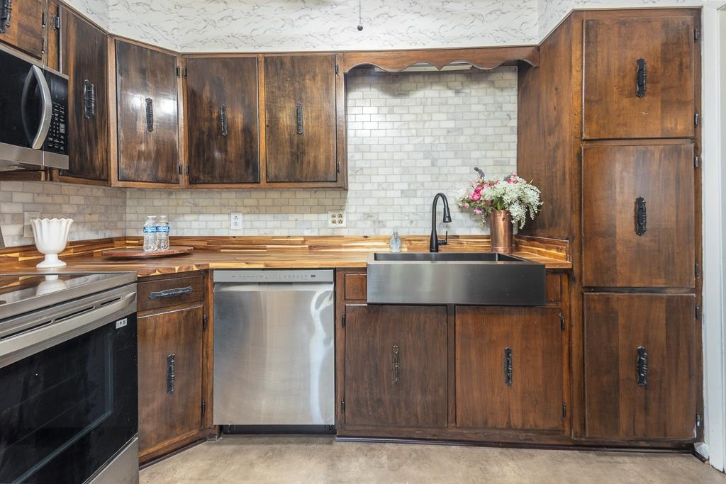 5750 Brighton-Clopton Road Brighton, TN 38011 - Photo 11 of 26 a kitchen with stainless steel appliances granite countertop a sink stove and refrigerator