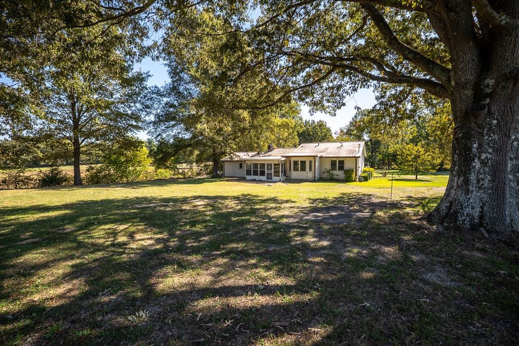 5750 Brighton-Clopton Road Brighton, TN 38011 - Photo 26 of 26 a view of a swimming pool with lawn chairs and large trees