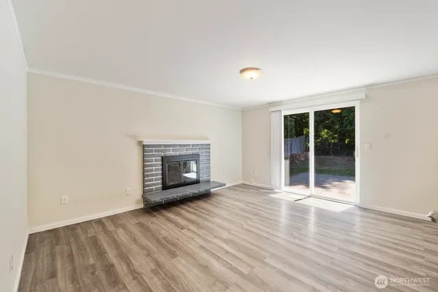 an empty room with wooden floor and fireplace