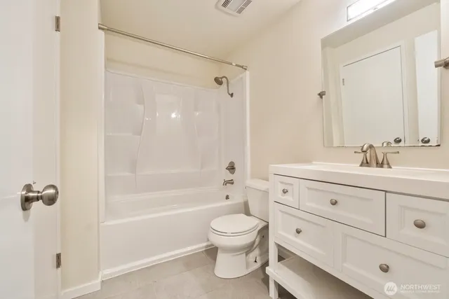 a bathroom with a toilet a sink a mirror and shower