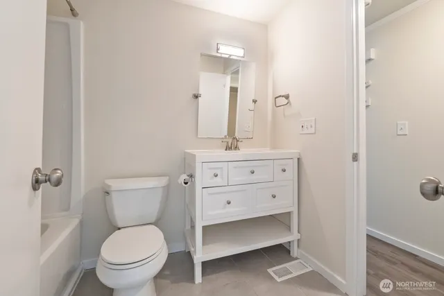 a bathroom with a toilet a sink and mirror