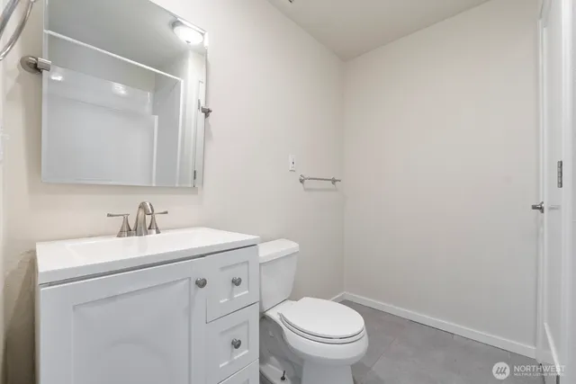 a bathroom with a toilet sink vanity and mirror