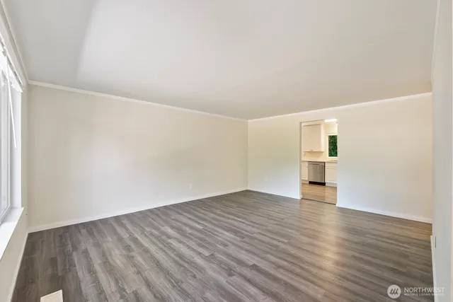 a view of empty room with wooden floor