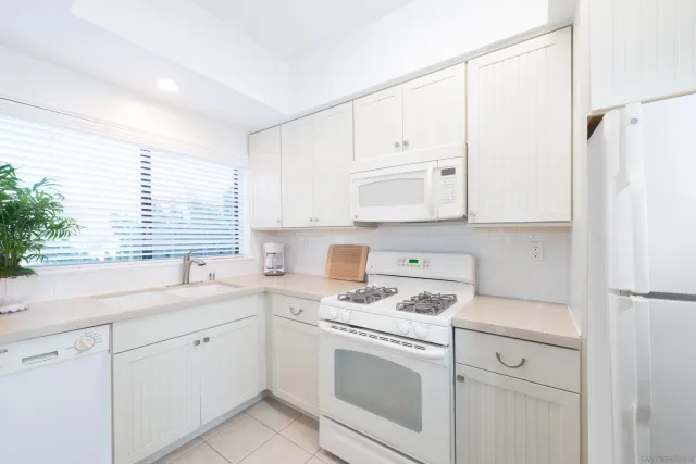 a kitchen with cabinets appliances a sink and a window