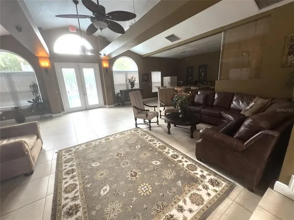 a living room with patio furniture and a chandelier