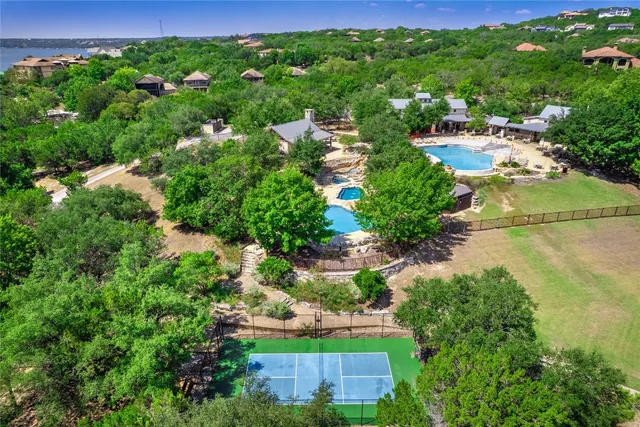 an aerial view of residential house with outdoor space and trees all around