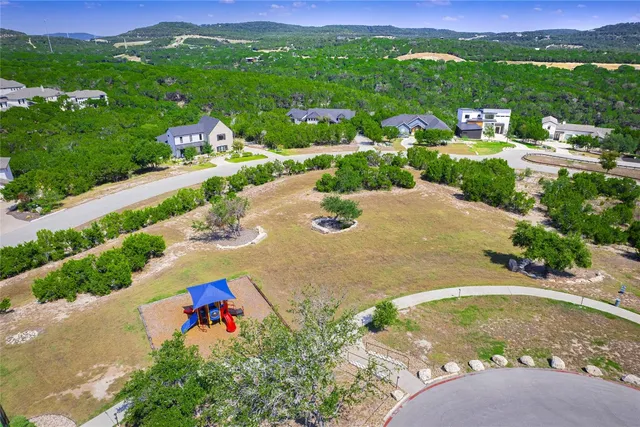 an aerial view of a house with a yard and lake view