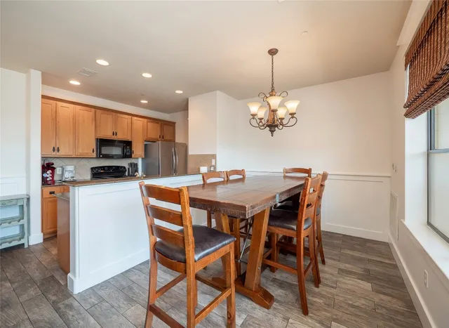 a dining room filled chandelier and wooden floor