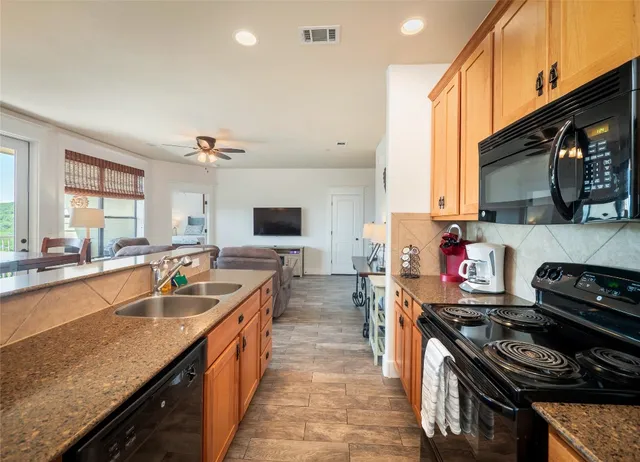 a kitchen with stainless steel appliances granite countertop a stove a sink and a microwave