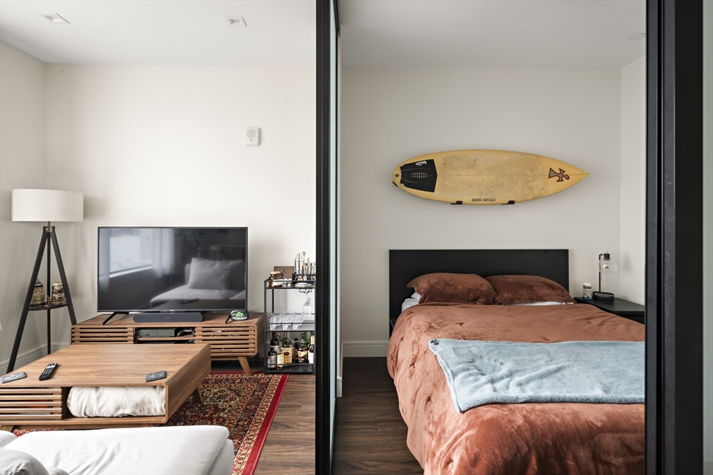 99 Sumner Street, Unit 413 Boston, MA 02128 - Photo 6 of 21 a bedroom with a bed and a flat screen tv