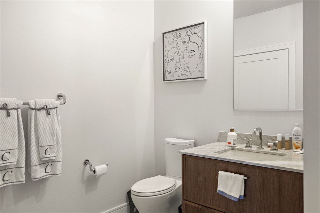 99 Sumner Street, Unit 413 Boston, MA 02128 - Photo 8 of 21 a bathroom with a granite countertop toilet sink and mirror