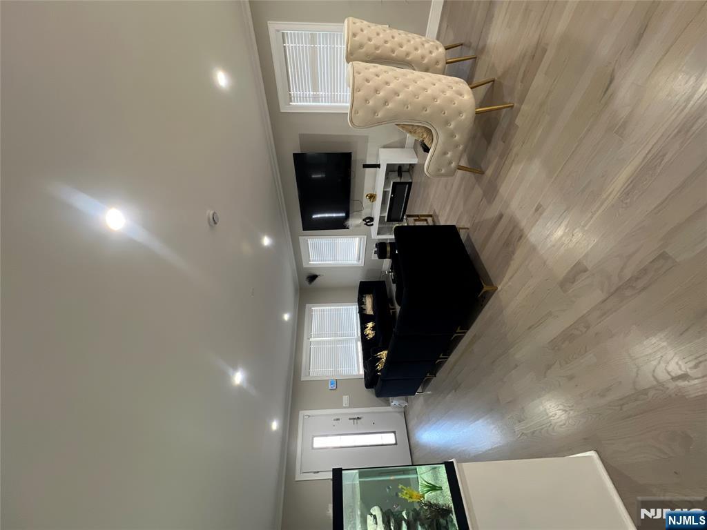 a living room with couches and kitchen view with wooden floor