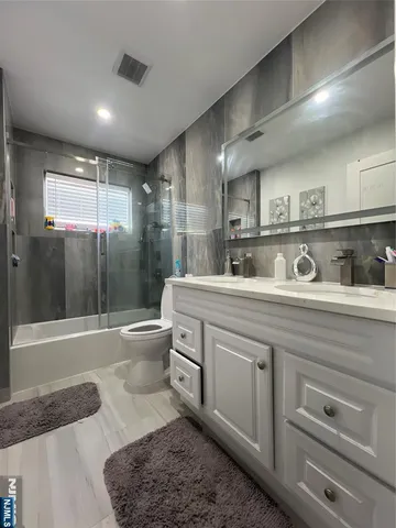 a bathroom with a double vanity sink toilet and shower
