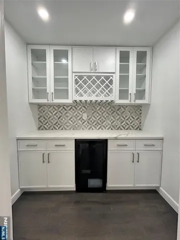 a kitchen with white cabinets and window