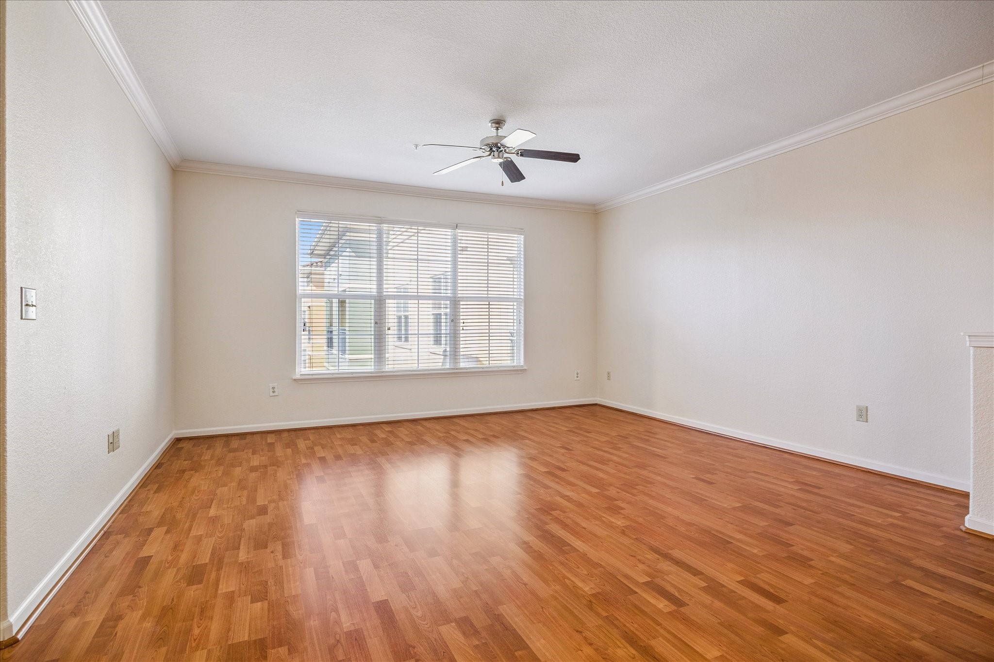 1711 Old Spanish Trail, Unit 448 Houston, TX 77054 - Photo 6 of 29 an empty room with wooden floor chandelier fan and windows