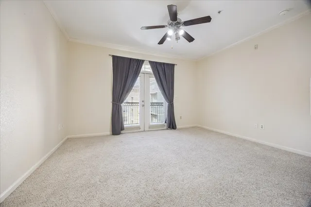an empty room with a ceiling fan and windows