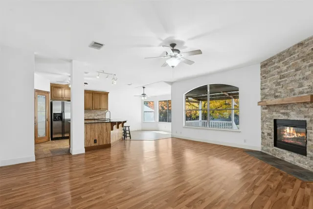 a view of empty room with a fireplace and wooden floor