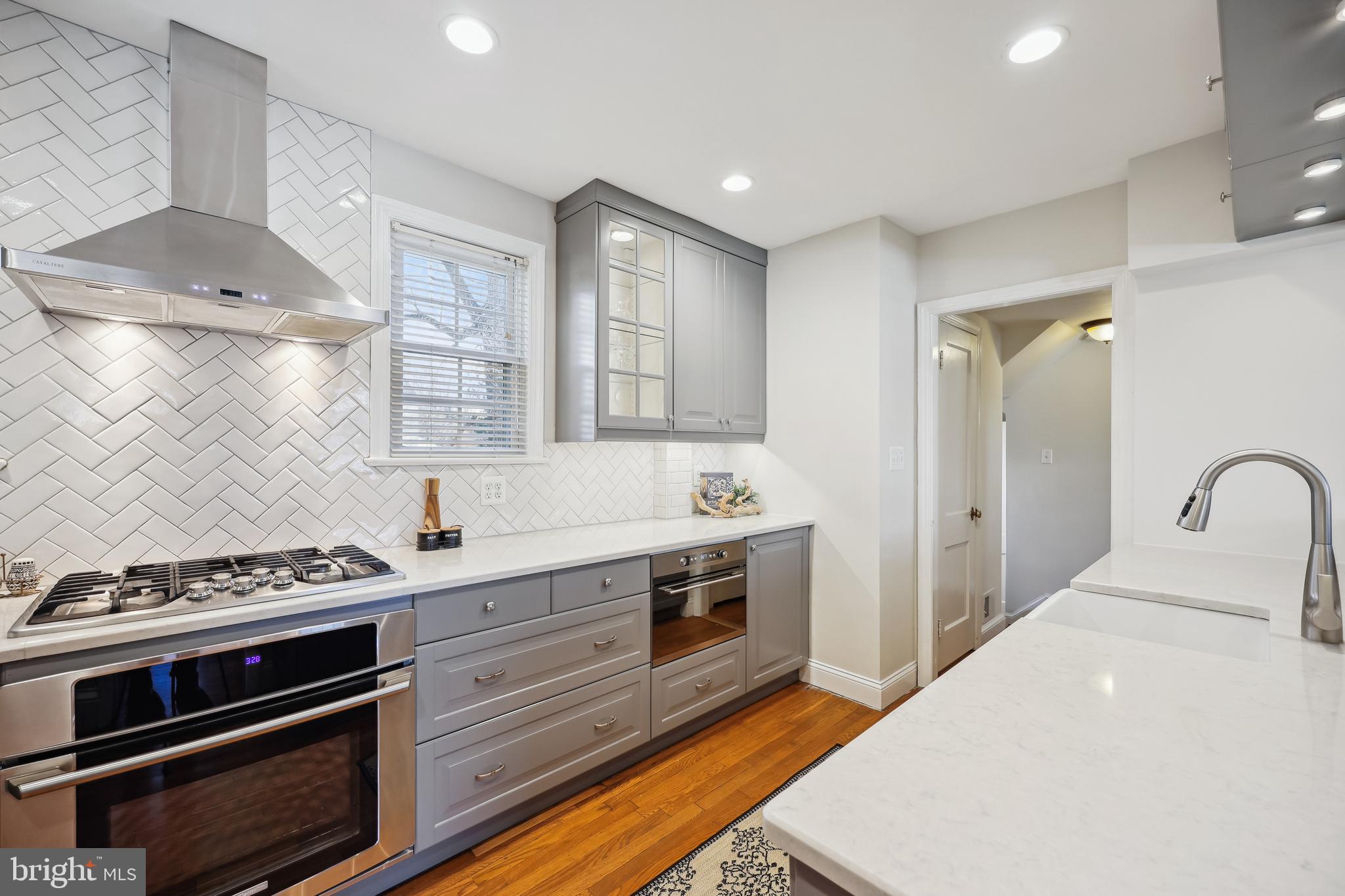 10121 Markham Street Silver Spring, MD 20901 - Photo 12 of 80 a kitchen with stainless steel appliances a stove a sink and cabinets