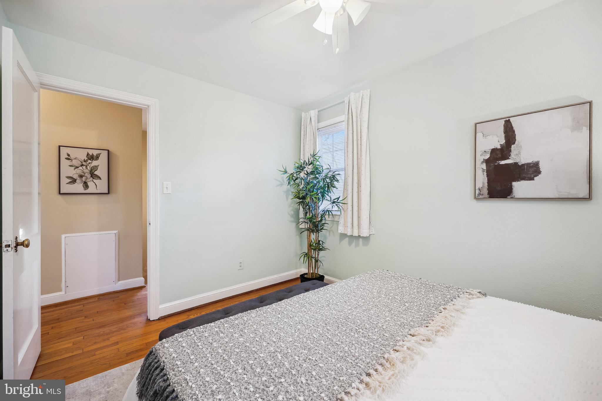 10121 Markham Street Silver Spring, MD 20901 - Photo 33 of 80 a bedroom with a bed and a potted plant