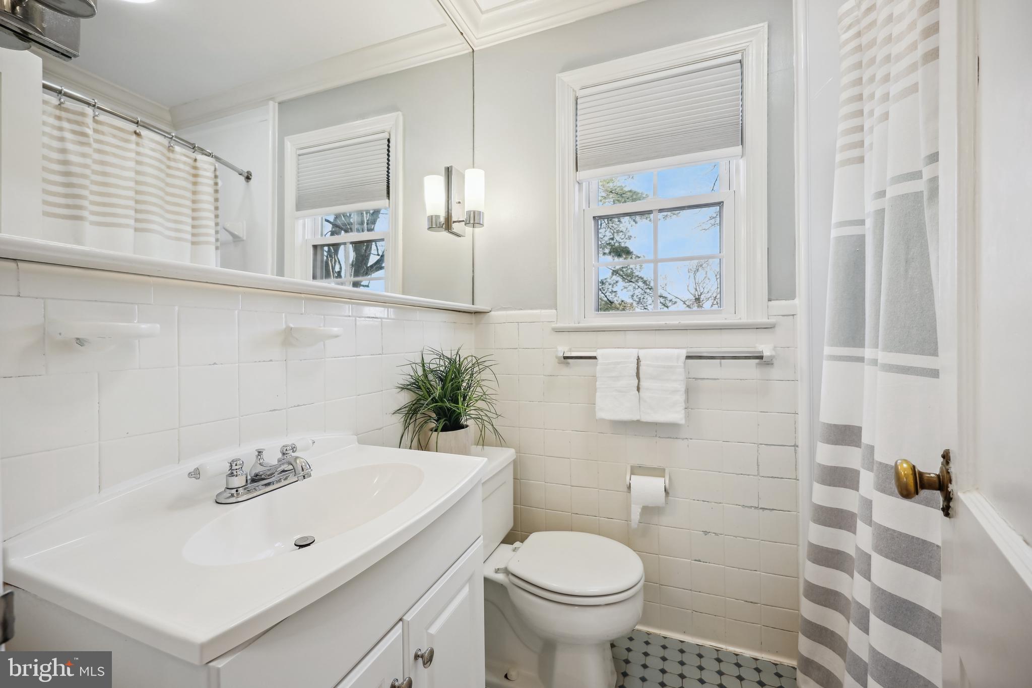 10121 Markham Street Silver Spring, MD 20901 - Photo 35 of 80 a bathroom with a sink a toilet and shower