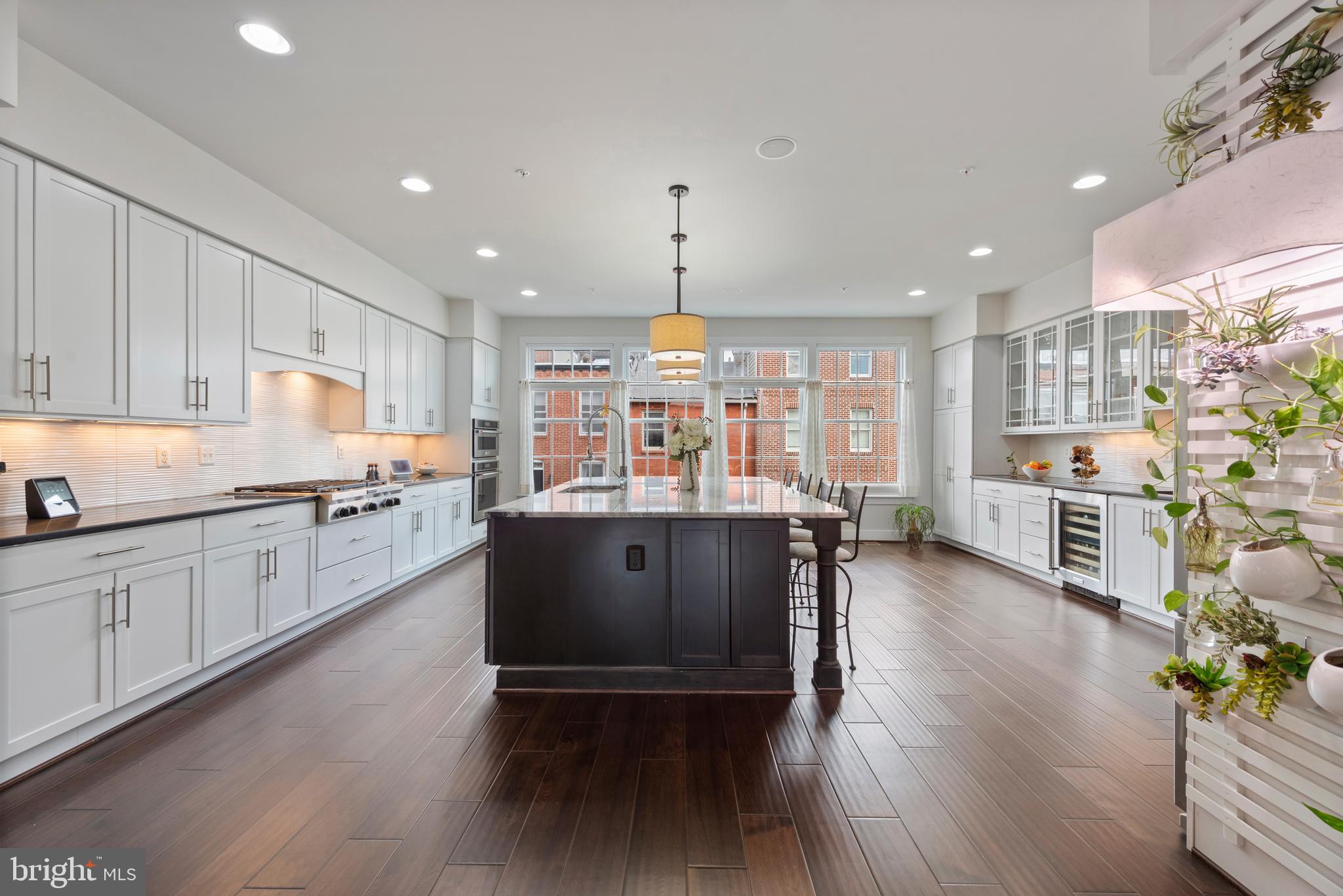 922 South Streeper Street Baltimore, MD 21224 - Photo 3 of 33 a kitchen with stainless steel appliances granite countertop wooden floors stove top oven and refrigerator