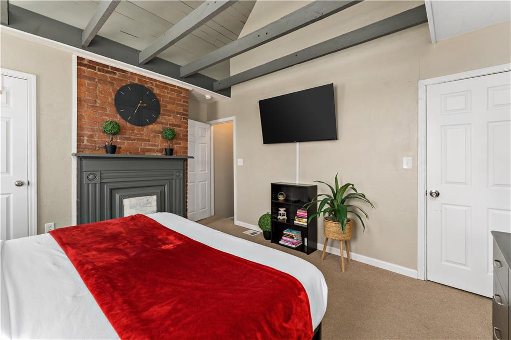 239 Albert Street Pittsburgh, PA 15211 - Photo 13 of 34 a bed room with a bed a flat screen tv and a fireplace