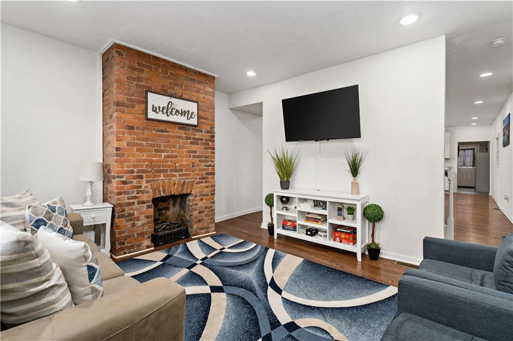 239 Albert Street Pittsburgh, PA 15211 - Photo 2 of 34 a living room with furniture a flat screen tv and a fireplace