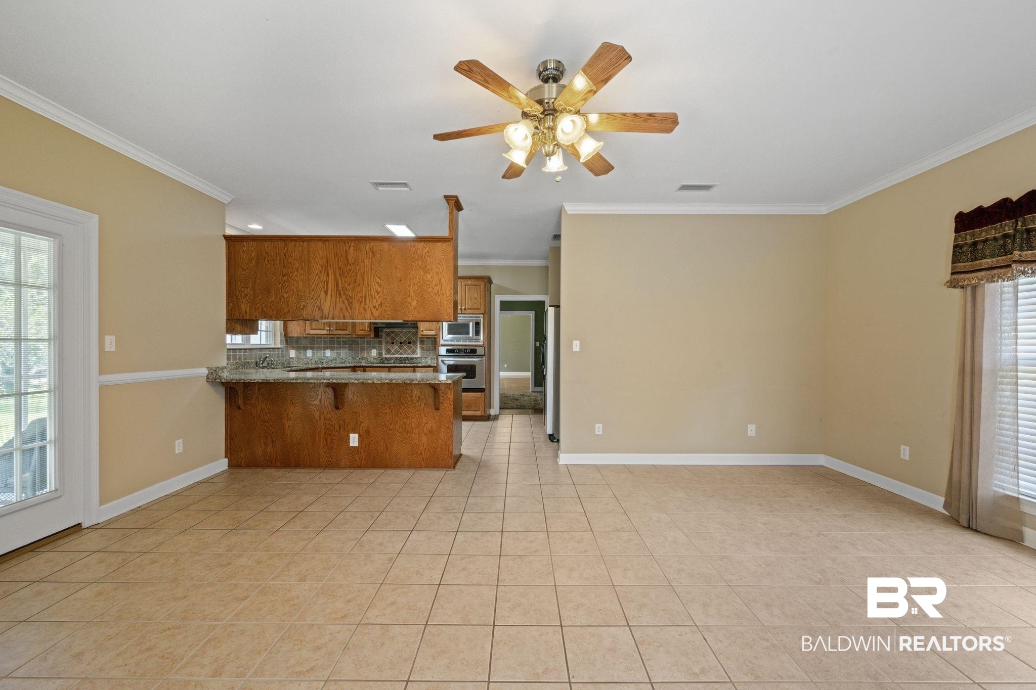 5618 Leytham Road Theodore, AL 36582 - Photo 27 of 60 Kitchen with tasteful backsplash, light tile patterned floors, kitchen peninsula, ceiling fan, and appliances with stainless steel finishes