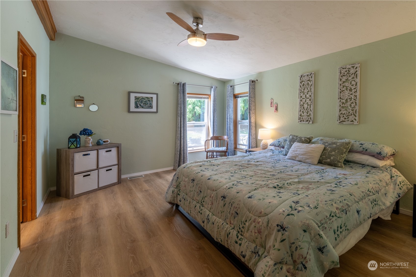 320 Fircrest Drive Sequim, WA 98382 - Photo 17 of 25 a spacious bedroom with a bed and a dresser with wooden floor