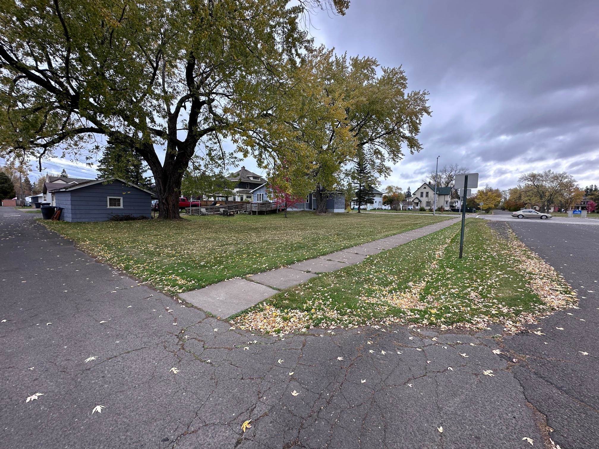 View of asphalt street with traffic signs, sidewalks, and a residential view