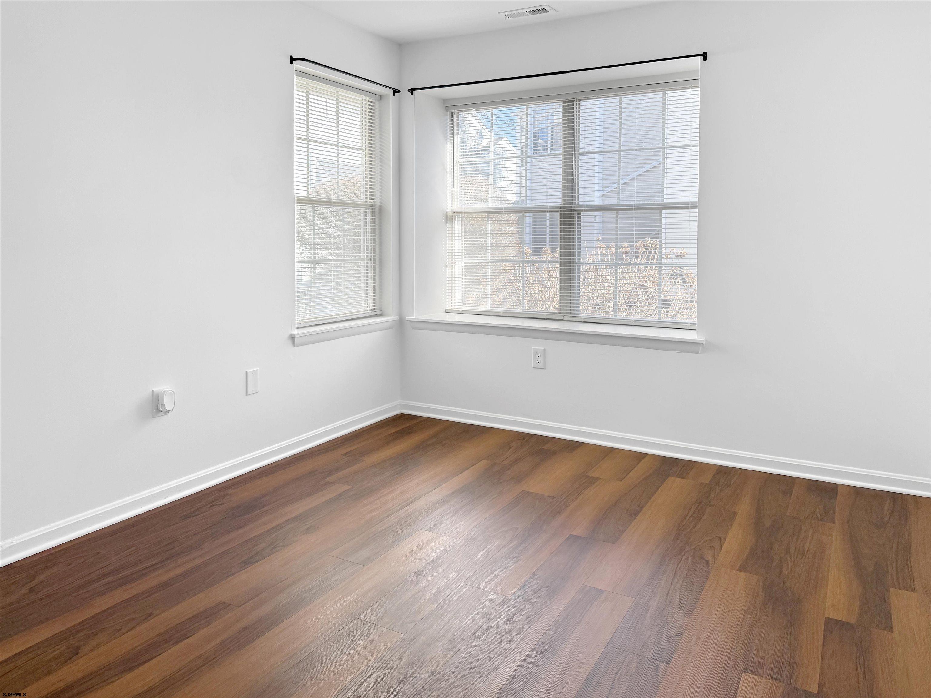 26 Malibu Way, Unit 26 Smithville, NJ 08205 - Photo 6 of 7 an empty room with wooden floor and windows
