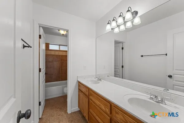 a bathroom with a tub a sink and a mirror