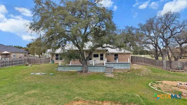 a view of a house with garden and a tree