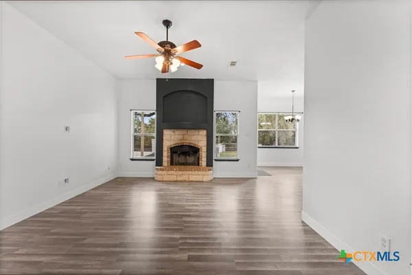 a view of a livingroom with wooden floor and a fireplace