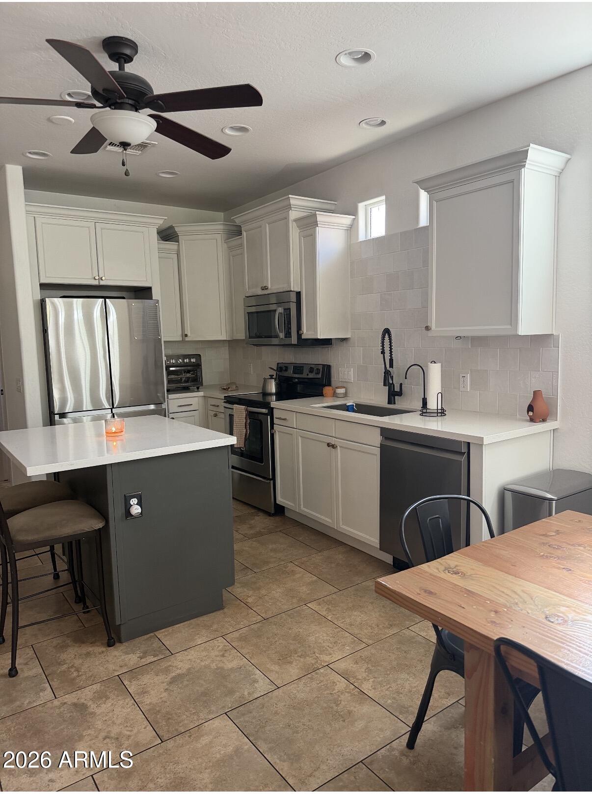 1377 South Chaparral Boulevard Gilbert, AZ 85296 - Photo 7 of 22 a kitchen with a sink a cabinets and chairs