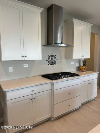 a kitchen with white cabinets and sink