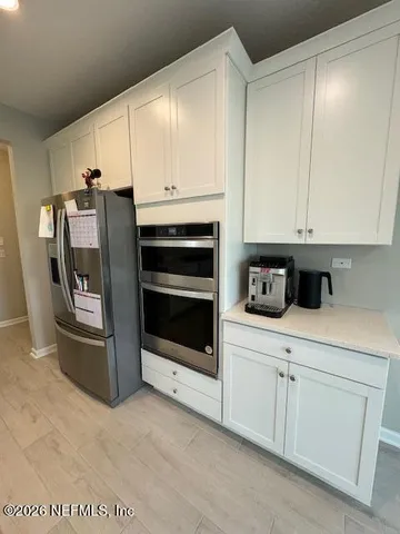 a kitchen with stainless steel appliances white cabinets and stove