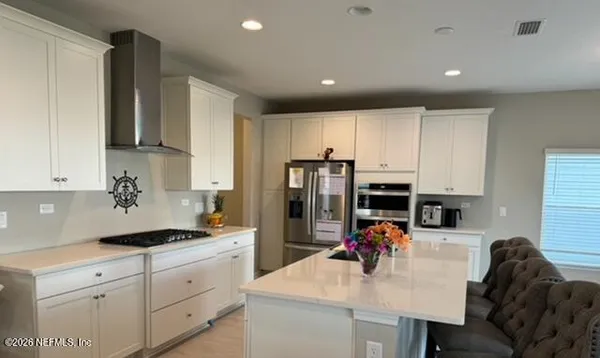 a kitchen with stove refrigerator and cabinets